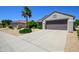 Wide driveway leads to this single story desert home with a two car garage and desert landscaping at 19892 N Shadow Mountain Dr, Surprise, AZ 85374