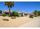 Well-maintained desert home with desert landscaping, palm trees, and a spacious driveway with a two car garage at 19892 N Shadow Mountain Dr, Surprise, AZ 85374