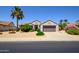Inviting single-story home with a well-maintained front yard, lush greenery, and a two-car garage at 19892 N Shadow Mountain Dr, Surprise, AZ 85374