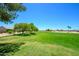 Scenic view of a lush golf course with green grass, trees and the desert in the background under a beautiful blue sky at 19892 N Shadow Mountain Dr, Surprise, AZ 85374