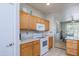 Well-lit kitchen featuring wood cabinets, granite countertops, and modern white appliances at 19892 N Shadow Mountain Dr, Surprise, AZ 85374