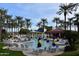 Resort style swimming pool surrounded by lounge chairs, palm trees, umbrellas, and landscaping at 19892 N Shadow Mountain Dr, Surprise, AZ 85374