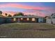 A backyard with a small patch of grass surrounded by decorative rock at dusk at 2015 W Weldon Ave, Phoenix, AZ 85015