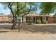 A single-story brick home features a covered parking, xeriscaped yard, and a Little Free Library at 2015 W Weldon Ave, Phoenix, AZ 85015