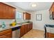 Functional kitchen featuring wood cabinetry, granite countertops, and a stainless steel dishwasher at 2015 W Weldon Ave, Phoenix, AZ 85015