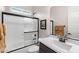 Clean bathroom with framed mirror, shower-tub combo with white door, and black fixtures at 2114 N Canelo Hls, Mesa, AZ 85207