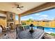 Spacious covered patio with a fireplace and dining area, perfect for entertaining near the pool and lush landscaping at 2114 N Canelo Hls, Mesa, AZ 85207