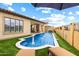 Inviting backyard pool area featuring a fireplace, lounge chairs, and a well-manicured artificial grass landscape at 2114 N Canelo Hls, Mesa, AZ 85207