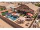 This backyard has a pool with umbrella coverage, a hot tub and a bar with seating at 21200 E Camacho Rd, Queen Creek, AZ 85142