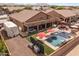 Spacious backyard featuring a pool, hot tub, outdoor kitchen and covered patio at 21200 E Camacho Rd, Queen Creek, AZ 85142