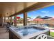 Relax in the hot tub on the covered patio overlooking the pool and landscaped yard at 21200 E Camacho Rd, Queen Creek, AZ 85142