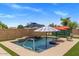 Private pool with waterfall feature, in-pool seating, and a desert landscape at 21200 E Camacho Rd, Queen Creek, AZ 85142