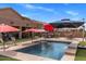 This backyard features a beautiful pool with waterfall, seating and desert landscape at 21200 E Camacho Rd, Queen Creek, AZ 85142