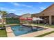 This backyard features a beautiful pool with waterfall, seating and desert landscape at 21200 E Camacho Rd, Queen Creek, AZ 85142