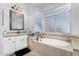 Luxurious bathroom featuring a soaking tub and granite countertop vanity at 22351 N 67Th Dr, Glendale, AZ 85310