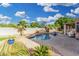 Inviting backyard pool with a rock waterfall, surrounded by palm trees and a brick patio at 22351 N 67Th Dr, Glendale, AZ 85310
