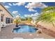 Sparkling swimming pool with a rock waterfall, surrounded by a brick patio and tropical landscaping at 22351 N 67Th Dr, Glendale, AZ 85310
