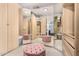 Spacious walk-in closet with mirrored walls, ample storage and pink ottomans, offering stylish organization at 22351 N 67Th Dr, Glendale, AZ 85310