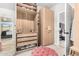 Walk-in closet featuring built-in shelves, drawers, a pink ottoman and a door leading to the bedroom at 22351 N 67Th Dr, Glendale, AZ 85310