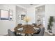 Stylish dining area with a wooden table set for four, modern art and plants at 22565 Rummler Ln, Maricopa, AZ 85138