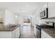 Bright, white kitchen with granite countertops, modern stainless steel appliances, and a view to the backyard at 22565 Rummler Ln, Maricopa, AZ 85138