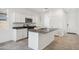 Modern white kitchen with granite countertops, stainless steel appliances, and a large center island at 22565 Rummler Ln, Maricopa, AZ 85138