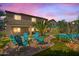 Inviting backyard featuring a fire pit with chairs, and lush landscaping with a tropical palm tree at 23523 N 117Th Dr, Sun City, AZ 85373