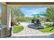 Beautiful backyard features a covered patio, lush landscaping, and a refreshing swimming pool with a charming waterfall feature at 23523 N 117Th Dr, Sun City, AZ 85373