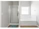 Clean bathroom featuring a shower and separate tub next to a window at 23523 N 117Th Dr, Sun City, AZ 85373
