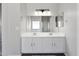 Bathroom featuring double sink vanity and a large mirror at 23523 N 117Th Dr, Sun City, AZ 85373