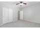 Bedroom with neutral walls, plush carpeting, a ceiling fan, and large closet with sliding doors at 23523 N 117Th Dr, Sun City, AZ 85373