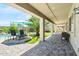 Spacious covered patio with brick flooring, seating area, and view of the lush backyard and pool at 23523 N 117Th Dr, Sun City, AZ 85373