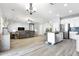 Open-concept living room with tile floors, modern lighting, and seamless transition to the kitchen at 23523 N 117Th Dr, Sun City, AZ 85373