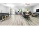 Bright living room with wood-look tile flooring, a comfortable sofa, and access to the backyard patio at 23523 N 117Th Dr, Sun City, AZ 85373