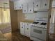 Traditional kitchen featuring white cabinetry, laminate countertops, and a functional layout at 2528 N Lema Dr, Mesa, AZ 85215