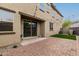 House backyard has artificial turf, brick patio, sliding glass doors, and string lights at 2540 N Stone Hill Rd, Buckeye, AZ 85396
