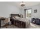 Neutral bedroom features a comfortable bed, a desk, and a ceiling fan with light at 2540 N Stone Hill Rd, Buckeye, AZ 85396
