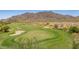 Lush golf course with manicured greens, sand traps, and a picturesque mountain backdrop at 2540 N Stone Hill Rd, Buckeye, AZ 85396