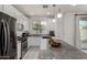Bright kitchen with white cabinets, granite countertops, stainless steel appliances, and an island with seating at 2540 N Stone Hill Rd, Buckeye, AZ 85396