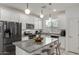 Modern kitchen with white cabinets, stainless steel appliances, granite countertops, and an island with bar seating at 2540 N Stone Hill Rd, Buckeye, AZ 85396