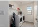 Well lit laundry room with a washing machine, dryer, shelf, and a window at 2540 N Stone Hill Rd, Buckeye, AZ 85396