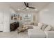 Bright living room with modern furnishings, a ceiling fan, tile floors, and a large sectional couch at 2540 N Stone Hill Rd, Buckeye, AZ 85396