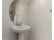 A pedestal sink and an oval mirror decorate the powder room at 2540 N Stone Hill Rd, Buckeye, AZ 85396