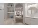 Bathroom featuring a large soaking tub, built-in shelves, and arched doorway at 3733 E Kachina Dr, Phoenix, AZ 85044