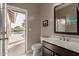 Bathroom featuring a sink, mirror, and convenient access to the outdoor pool and patio area at 3733 E Kachina Dr, Phoenix, AZ 85044