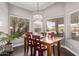 Cozy dining area with a wooden table, red chairs, and a view of the pool through large windows at 3733 E Kachina Dr, Phoenix, AZ 85044