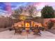 An outdoor living space features an elegant fireplace with seating and manicured landscaping at 3733 E Kachina Dr, Phoenix, AZ 85044