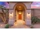 Covered front entrance with arched portico and wooden door at 3733 E Kachina Dr, Phoenix, AZ 85044