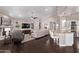 Open-concept living space with a fireplace, ceiling fan, and easy access to the kitchen with a breakfast bar at 3733 E Kachina Dr, Phoenix, AZ 85044