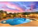 Outdoor space with a sparkling pool, waterfall feature, and a covered outdoor kitchen and dining area at 3733 E Kachina Dr, Phoenix, AZ 85044